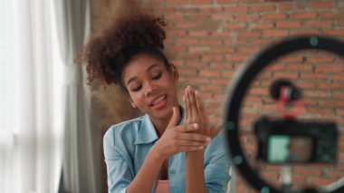 Kadın nüfuzlu kişi, sosyal medya veya blog için canlı yayın yapan video klip eleştirmeni Cilt Bakımı 'nı çekiyor. Kozmetik stüdyosu ışıklandırmalı mutlu genç kız çevrimiçi pazarlama oturumu yayını için..