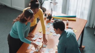 Yetenekli tasarımcı görüşü logo tasarımı ve yazma konsepti için beyin fırtınası fikri. Yapışkan notları paylaşarak insanların iş görüşü tartışır ve konuşur. Sempozyum.