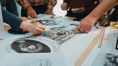 Profesyonellerden oluşan çeşitli bir ekip, canlı bir çalışma alanında yaratıcılık ve yenilikçi tasarım sergileyen planlar ve teknik araçlarla çevrili dinamik işbirliğine girişiyor. SACTR