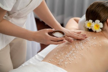 Lüks spa salonlarında sıcak mum ışığında cilt bakımı yaptıran kadın müşteri. Sağlık Spa vücut fırçasında tuz temizleme güzellik tedavisi. Sessiz.
