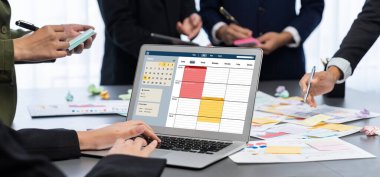 Analizci ekibi yaratıcı ve analitik beyin fırtınası fikri için bilgisayar ekranında BI veri paneli olan yapışkan bir not kullanıyor. Pazarlama stratejisi için finansal veri görselleştirme teknolojisini analiz et. Dahi.