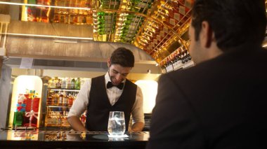Akıllı barmen, lüks bir tezgahta arkadaşını beklerken limonlu cin kokteyli ikram ediyor. Barmen, canlı gece hayatı parti atmosferinde mükemmel hizmet veriyor. Vinosity.