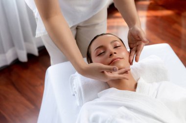 Kafkasyalı kadın stres önleyici kafa masajından ve lüks tatil beldesi ya da otel spa salonundaki modern ışık ortamında yüz güzelliği eğlencelerini şımartmaktan hoşlanıyor. Sessiz.