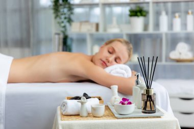 Aromaterapi masajı gündüz atmosferinde ya da spa salonunda bulanık bir kadına odak dekor ve spa aksesuarları kurarak tatil köyünde ya da otel arka planında keyifli aroma spa masajı yapan bir masaj. Sessiz.