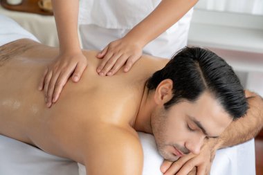 Kafkas erkek müşteri stres önleyici spa masajının keyfini çıkarıyor ve lüks otel veya oteldeki gündüz açık hava ortamında güzellik derisi eğlencesi ile şımartıyor. Sessiz.