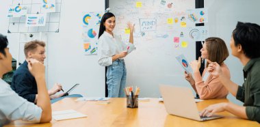 Genç ve güzel lider pazarlama stratejisini sunarken, uzman yatırımcı ve proje yöneticisi de yeni başlayan iş toplantısında iş performansını analiz etmeye çalışıyor. Çok ırklı bir grup. Tertemiz..