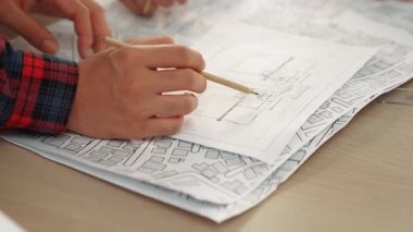 Mimari ekipmanlarla toplantı masasında ev tasarımı üzerine profesyonel mühendis ekibi tartışması ve modern ofiste bina planı dağılımı. Eline odaklan. - Yakın çekim. Tanımlama.