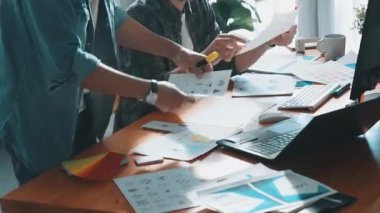 Takım ayakta dikilirken ve yorum yaparken müdürün fikir yazma konusunda üst düzey görüşü. Profesyonel tasarımcı logosu renk paletine bakarken ve renkli kalemle fikri kağıda yazarken. Sempozyum.