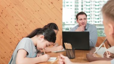 Profesyonel Kafkas öğretmeni çeşitli öğrenciler test yaparken ev ödevini açıklıyor. Çok kültürlü liseli çocuklar sınıfta otururken kağıda cevap yazıyorlar. Yaratıcı eğitim. Öğretim