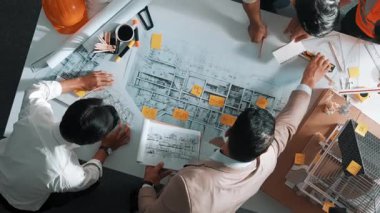 Becerikli mühendis ekibinin ev inşaatından bahsedişinin en alt görüntüsü. Mimar ya da tasarımcı grubunun planlar hakkında beyin fırtınası yapmak için tartışan ve yazan hava görüşü. Hizalama.