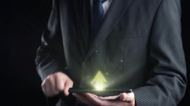 Resmi takım elbiseli bir işadamı, borsa eğilimleri ve büyüme göstergelerini gösteren, mali başarıyı ve teknolojik ilerlemeyi simgeleyen bir akıllı telefon taşıyor. Dörtgen