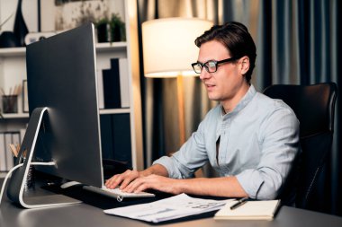 Akıllı iş adamı iş paragrafı dinamik pazarlama analizi planını analiz ediyor. Kağıt kağıtları ve bilgisayar monitörü raporlarını gece evdeki belge verileriyle karşılaştırmak için hazırlıyor. Bireysel.