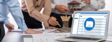 İç mimar tasarımcı grubu, daha kesin tasarım için planlar ve dizüstü bilgisayar ekran mimari yazılımı üzerinde birlikte tartışıyorlar. Modern ev tasarımı ve yenileme. İçgörü