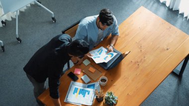 Toplantı masasında dizüstü bilgisayar kullanarak verileri analiz etmek için birlikte çalışan iş adamlarının üst görüşü. Finansal grafiğe bakarken çeşitli yaratıcı insanlar planlarını tartışıyor ve beyin fırtınası yapıyorlar. Cemaat.