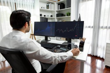 Akıllı tüccar işadamı, modern merkez ofisindeki araştırma pazarında en yüksek kârlı finansal teknolojiye yatırım yaparak bilgisayar üzerinde iki dinamik borsa yatırım ekranını analiz ediyor. Tahmin et..