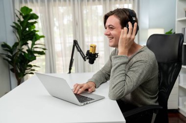 Sunucu kanalı, gülümseyen akıllı yayıncı kaydı, senaryosu ve akıllı telefonuyla sosyal medyada sohbet programı, kulaklık takarak modern ev stüdyosundaki video flamalarını kaydediyor. Bireysel.