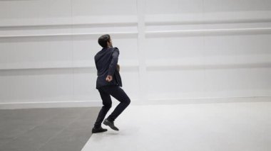 Proje yöneticisi, beyaz arkaplanlı canlı müziğe geçerken başarı projesini kutlamak için dans ediyor. Beyaz arka planda dans ederken çantasını tutan yetenekli bir iş adamı. Uzayı kopyala Sevinçli..