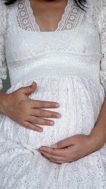 Hamile bir kadın çocuğuna bakarken kendini mutlu hissediyor. Hamile karnında bebek taşıyan hamile bir anne. Doğum öncesi bakım ve kadın hamileliği konsepti.