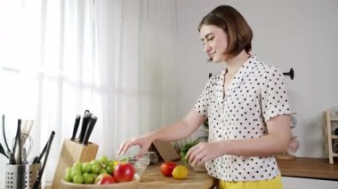 Çekici beyaz anne salata yapmak için taze sebze doğruyor. Mutlu enerjik akıllı anne kahvaltıda sağlıklı yemek pişirirken modern mutfakta çalışıyor. Yemek hazırlama konsepti. Pedagoji.