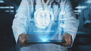 Doktor beyin anatomisi hologramıyla tablet gösteriyor. Beyin yapısını analiz ederken ve beyin ameliyatına hazırlanırken tıbbi çalışanların elinde cihaz ve teşhis semptomları var. İyileştirici.