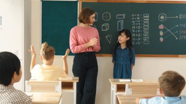 Asyalı kız sınıfın önünde kendinden emin bir şekilde yürürken beyaz bir öğretmen gönüllü istiyor. Zeki öğrenci, öğretmenler el çırparken elini kaldırdı ve soruyu cevapladı. Pedagoji.