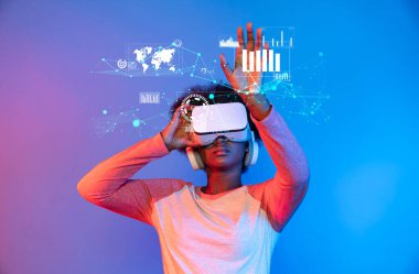 Genç bir kadın, finansal veri analizleriyle dolu canlı bir dijital ortamı ve görüşler için etkileşimli görselleştirmeleri keşfetmek için sanal gerçeklik kulaklığı takıyor. XDMCP