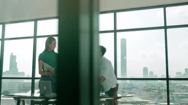 Bir grup yetenekli iş adamı toplantı masasında dizüstü bilgisayar ve istatistik belgeleriyle mali istatistik hakkında tartışıyor, beyin fırtınası yapıyor, fikir paylaşıyor, plan yapıyor ve strateji geliştiriyor. Şehir manzarası. İzleme