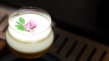 Tutkulu meyve suyu bardağında dönüşümlü, özel, ferahlatıcı, pembe çiçekle süslenmiş, lüks gece klübünde gece hayatı karışımı sergilenen bir içecek. Vinosity.