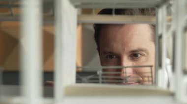 Kafkasyalı mimar mühendisinin yakın çekimi ev inşaatını denetlemek ve bina malzemelerini kontrol etmek. Proje yöneticisi modele dikkatlice bakarken kalemi işaret ediyor. Yönlendirici.