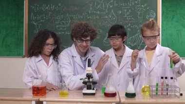 Akıllı öğretmen kimyasal teoriyi açıklarken ve analiz ederken yetenekli çocuk tüpü. Heyecanlı çeşitli öğrenci öğrenimi ve yeni yenilikçi fikir geliştirme çalışmalarının keyfini çıkarın. Pedagoji.