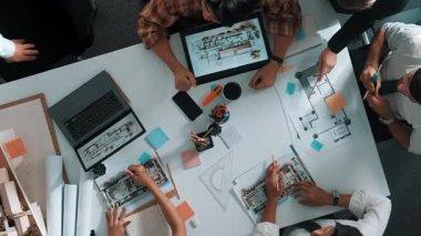 Ev modeli ve dizüstü bilgisayarla toplantı masasında otururken planda yazan akıllı mimar mühendisinin üst görüntüsü. Becerikli bir yönetici bina inşaatı konusunda çalışıyor. Hizalama.