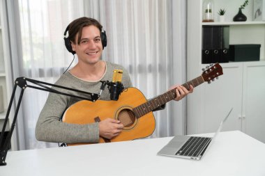 Akıllı şarkıcı görünümlü kamerada sunucu kanalı, şarkı söylerken gitar çalmak, sosyal medya kanalında yayın yapmak, modern stüdyo kaydında video kaydedici olarak kulaklık takmak. Bireysel.
