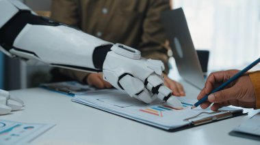Robotik bir el, bir insana iş analizi görevini tamamlamasında, teknolojinin modern ofis ortamlarına entegrasyonunu geliştirmek için yardımcı olur.