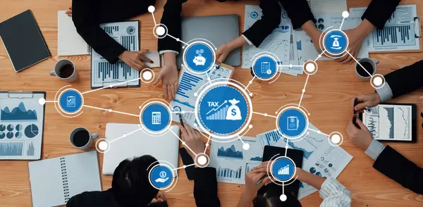Vergi stratejileri, dijital çizelgeler ve takım işbirliğinin yer aldığı bir iş toplantısının havadan görüşü, mali planlama ve analizi vurguluyor. Dostluk