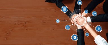 Çeşitli ellerin bir araya gelip siber güvenlikteki işbirliğini sembolize ettiği tepeden tırnağa bir bakış. Güvenliği temsil eden teknoloji ikonları modern iş stratejilerini ve bağlantıları geliştirmektedir. Dostluk