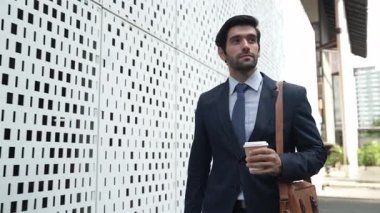 İş adamı telefona cevap verir ve iş yatırımları hakkında konuşur. İş planı, pazarlama stratejisi ya da çalışma hakkında konuşmak için akıllı telefonla konuşurken sokakta yürüyen mutlu bir yönetici. Sevinçli..