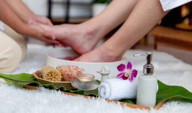 Adam lüks kaplıcalarda mutlu ayak masajına devam ederken, masör de hafif gün ışığı atmosferinde refleksoloji terapisi ya da otel ayak spa 'sında. Sessiz.