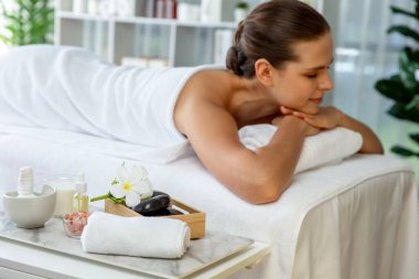 Aromaterapi masajı gündüz atmosferinde ya da spa salonunda bulanık bir kadına odak dekor ve spa aksesuarları kurarak tatil köyünde ya da otel arka planında keyifli aroma spa masajı yapan bir masaj. Sessiz.