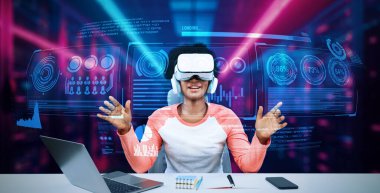 Masada kitap ve dizüstü bilgisayarla ödev yaparken metaevreleri birbirine bağlayan dizüstü bilgisayar ve artırılmış gözlük kullanan bir kız. Öğrenci holograma bakıyor ve yapay zekayı kullanıyor. Yaratıcılık.