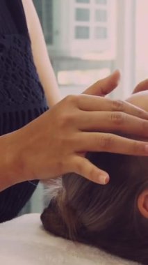 Lüks bir spa merkezinde masaj terapisti tarafından yüz masajı ve spa tedavisi için kaplıcaya uzanmış rahat bir kadın. Sağlık, stres atma ve gençleştirme kavramı.