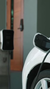 Elektrikli araç şarj istasyonu olan, sağlıklı ve temiz bir çevreyi teşvik eden yenilikçi bir aile kavramı. Sürdürülebilir, temiz enerji teknolojisiyle çalışan elektrikli araç..