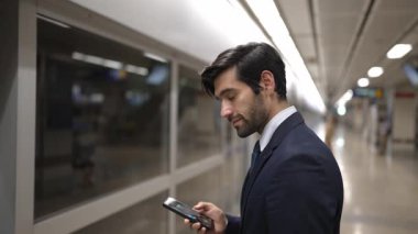 Profesyonel iş adamı tren istasyonunda dikilirken kameraya gülümser. Beyaz yetenekli yönetici kameraya bakarken kendine güvenen bulanık bir geçmişi var. Sevinçli..