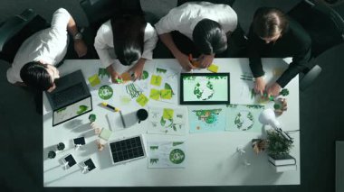 Yönetici yöneticisinin üst görünümü toplantılarda tablet temiz enerji gösterir. İş adamlarının sürdürülebilir çevre yatırımlarını planlamak ve yatırım yapmak için birlikte çalıştıklarına dair havadan bir bakış açısı. Hizalama.