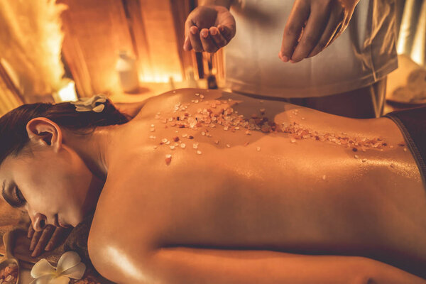 Женщина-клиент, проводящая пилинг в роскошном спа-салоне с теплым свечой окружающей среды. Косметическое лечение бальзамическим скрабом в Health spa scrub. Quiescent