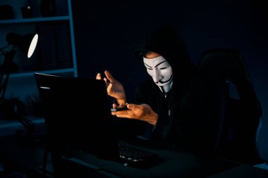 Beyaz gülümseyen isimsiz suçlu maskesi kurbana sesleniyor, kişisel bilgileri hacklemeye ikna ediyor, veri sunucu sistemindeki bilgisayar korsanlarının kullandığı şifreleme programını paylaşıyor. Tahmin et..