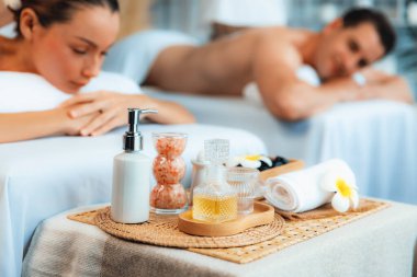 Aromaterapi masajı gündüz atmosferinde ya da spa salonunda bulanık bir kadına odak dekor ve spa aksesuarları kurarak tatil köyünde ya da otel arka planında keyifli aroma spa masajı yapan bir masaj. Sessiz.