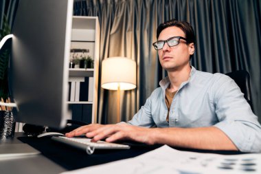 Akıllı iş adamı iş paragrafı dinamik pazarlama analizi planını analiz ediyor. Kağıt kağıtları ve bilgisayar monitörü raporlarını gece evdeki belge verileriyle karşılaştırmak için hazırlıyor. Bireysel.