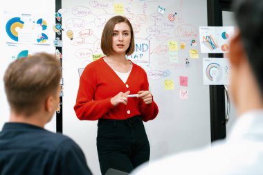 Profesyonel çekici kadın lider, modern iş toplantı odasında beyin fırtınası zihin haritalama istatistikleri ve renkli yapışkan notlar kullanarak yaratıcı pazarlama planını sunuyor. Tertemiz..