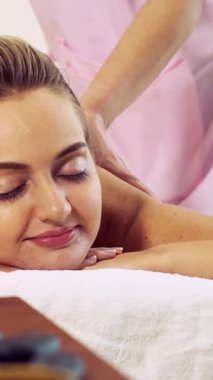 Rahat bir kadın profesyonel masaj terapistiyle lüks kaplıcalarda masaj yaptırıyor. Sağlık, şifa ve rahatlama konsepti.