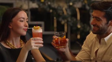 Gülümseyen güzel bir kadın, Paloma kokteyli ile kadeh kaldırıyor. Eski moda, zevkli ve zevkli bir çiftin bardaki özel gece kulübü partisinde canlı sohbetin tadını çıkarıyor. Vinosity.
